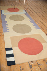 Cinnabar red circle, striped end, and flatweave texture of a contemporary Kilim runner.