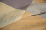 Handwoven contemporary Kilim rug detail with abstract beige, slate, and violet blocks.