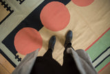 Vintage contemporary kilim featuring abstract geometric pattern, coral circles, and black lines.