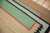 Contemporary Kilim rug's abstract geometric paths in pale emerald green, cinnabar red, and charcoal.