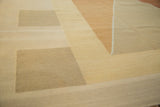 Close-up of modern Kilim rug's smooth flatweave texture and alternating geometric shapes in sand, gold, and beige.