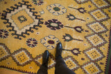 A close look at the soft, full pile of a vintage Moroccan rug with saffron and purple floral motifs.