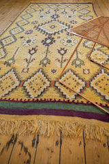 Angled view of a vintage Moroccan rug runner's paneled diamond border and plush saffron pile.