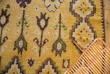 Plush hand-knotted wool pile of a vintage Moroccan rug in saffron yellow with floral motifs.