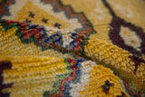 Thick, hand-knotted wool pile of a vintage Moroccan rug in saffron yellow, green, and purple.