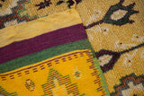 Colorful flatweave kelim back of a vintage Moroccan rug, contrasting with its plush saffron pile.
