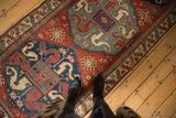 View of an antique Kazak runner's bold Caucasian geometric patterns and low-pile texture.