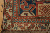 The reciprocating pawn motif and serrated leaf border on a late 19th-century Caucasian Kazak rug.