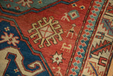Large dragon motif with stylized human and animal figures on a worn, antique Kazak rug.