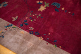 Close-up of antique Art Deco rug showing crimson red field transitioning to beige, with sprawling floral vines.