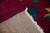 Intact side cord selvage, hand knotted foundation, and fringe on a crimson rug.