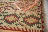 Vintage Turkish Kilim carpet section: ivory, red, green geometric rams horn motifs and fringe.