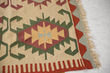 Vintage Turkish Kilim carpet corner with flatweave, intact fringe, and red, green, ivory border.