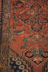 Close-up of extensive pile wear exposing the foundation and a visible hole on the antique Fereghan rug.