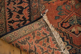 Antique Fereghan rug's woven foundation, fringed edge, and red Lotto motif border detail.