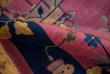 Folded Art Deco rug showing soft raspberry pink pile and cobalt blue stylized leaves.
