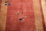 Art Deco floral motif with blue leaves on the plush copper-toned pile of a vintage Nichols rug.