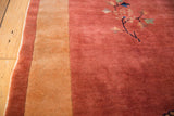 Intact selvage and full pile on a copper Art Deco Nichols rug with a sand border and floral spray.