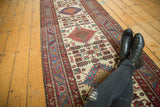 Vintage Karaja runner displaying its column of geometric medallions and serrated red and blue border.
