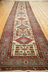Full-length perspective of a Persian Karaja runner with geometric medallions on an ivory ground.
