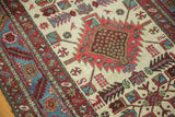 Close-up of a vintage Karaja's serrated red medallion, geometric birds, and multi-colored border.