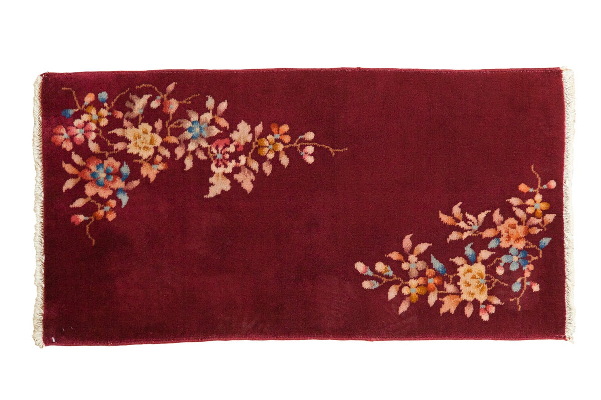 Vintage Nichols Art Deco rug runner with asymmetrical floral sprays over a rich burgundy field.