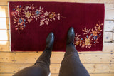 Vintage Nichols Art Deco rug seen from above, showing scale, burgundy field, and asymmetrical floral sprays.