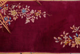 Asymmetrical corner floral sprays on the burgundy field of a vintage Nichols Art Deco rug.