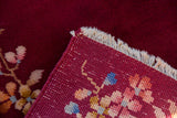 Flipped corner showing the hand-knotted foundation and burgundy pile of a vintage Nichols rug.