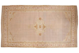 Antique Agra carpet with a central medallion on an open, abrashed mauve field with gold and ivory motifs.