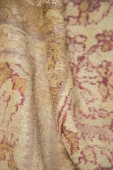 Soft wool pile of an antique Agra carpet showing high-low texture and time-softened mauve and gold tones.