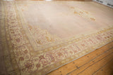 Low perspective on an antique Agra carpet's vast, abrashed mauve ground and textured wool pile.