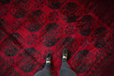 Cherry red vintage Ersari carpet, dark navy teal elephant guls, thick pile, shoes.