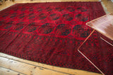 Corner of vintage Ersari rug featuring cherry red field, dark navy gul motifs, and intact selvage.