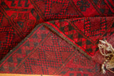 Folded vintage Ersari rug displaying cherry red elephant gul motif pile and hand-knotted back.