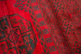 Thick cherry red wool pile with dark dusty navy teal elephant footprint gul motifs.