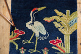 Collector Peking rug detail showing a bird motif against a dense, cobalt blue wool pile.
