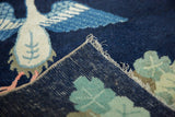 Hand-knotted Peking pictorial rug corner showing indigo pile, bird motif, intact selvage.