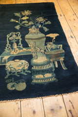 Antique Chinese Peking rug detail: celadon fishbowl, fish, and ivory offerings on deep blue.