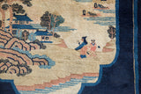 Detail of the pictorial village scene on a collector Peking rug, with villagers in dusty blush and cobalt blue.