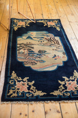 Collectible antique Peking rug with a pictorial landscape medallion on a deep indigo ground.