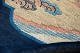 Evenly clipped wool pile of an antique Peking rug showing indigo, sand, and pale rose details.