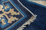 Intact side cord selvage and ivory fringe on the hand-knotted corner of an antique Peking rug.