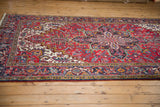 Vintage Heriz carpet with cherry red, navy, and ivory geometric floral motifs.