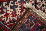 Detailed hand-knotted back and plush front pile of a vintage Mehrivan rug's corner with fringe.