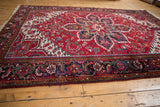 A vintage Mehrivan carpet showing its large geometric center medallion and rich cherry red field.