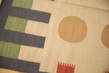 Contemporary Kilim rug featuring a dusty gold circle, charcoal rectangles, and terracotta motif.