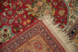 Corner view of a vintage Hereke rug shows its full pile, hand-knotted back, and intact selvage.