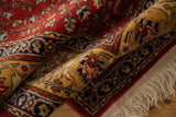 The plush, full pile and sand-colored floral arabesque border of a vintage rug.