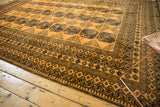Thick, lustrous pile and intricate navy borders of a saffron-colored vintage Daulatabad carpet.